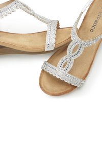 Silberne Sandalen mit dekorativen Strasssteinen und gewellten Kanten, ausgestattet mit einer weichen, beige Wildledersohle und einem komfortablen Sohlen-Design.