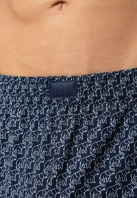 Blauwe katoenen korte broek met een herhalend wit olifantenpatroon. Voorzien van een elastische tailleband en een stoffen label met de merknaam "mey."