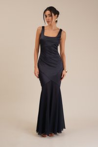 Navy satin evening gown featuring a fitted bodice, square neckline, and flared chiffon hem. Smooth texture with gathered design details.
