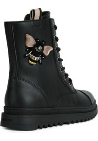 Černé kožené kotníkové boty s texturovaným povrchem, zdobené výšivkou dekorativní včely. Šněrovací design a robustní gumová podrážka.
