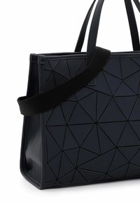 Czarna geometryczna torba na ramię z teksturowaną powierzchnią w trójkątne wzory, podwójnymi uchwytami u góry oraz odczepianym czarnym paskiem na ramię.