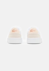 Hvite sneakers med en beige semsket aksent på hælen og en brodert logo. Glatt tekstur med avrundet tå og flat såle.