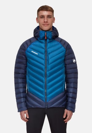 Blue and navy insulated jacket with a chevron design, zip closure, hood, and logo detail on the left arm. Textured fabric.