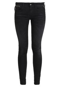 Pantalones vaqueros ajustados negros con una textura suave, que presentan un bolsillo con cremallera a la izquierda y un sutil desgastado a lo largo de las piernas. Diseñados con una pretina estándar.