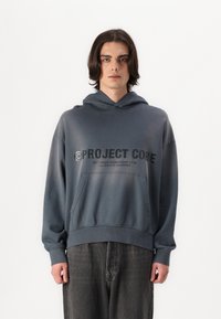 Grauer Hoodie mit Kängurutasche und Zugkordelkapuze. Die Vorderseite zeigt großen schwarzen Text, mit gerippten Bündchen und Saum.