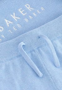 Svijetloplave pamučne trenirke s rebrastim pojasom, koje imaju vezicu i bijeli izvezeni logo "Baker by Ted Baker."