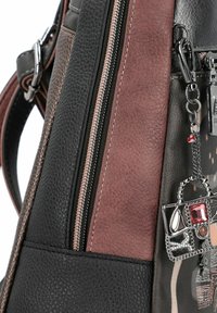 Zaino in pelle texturizzata nera e marrone con una cerniera argentata, dotato di un charm decorativo a forma di borsa attaccato sul lato.