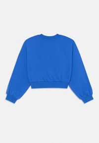 Kurtā, zila džemperis, kas izgatavots no mīksta kokvilnas. Satur garas, pūkainas piedurknes un ribinātu apkakli un apakšmalu ciešai pieguvei.