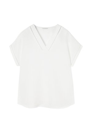 Top blanco de cuello en V con mangas cortas tipo capa, que presenta acentos de costura horizontal a lo largo del escote y las mangas. Textura de tela suave.
