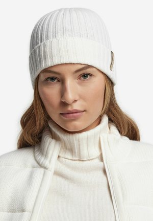 Witte gebreide muts met een ribbeltextuur en een vlak, opgerold rand. Voorzien van een klein metalen logo-accent aan de zijkant.