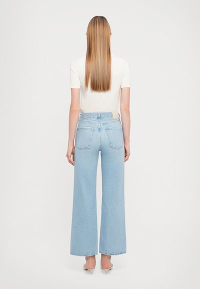 Jeans ampi di colore azzurro realizzati in denim, con vita alta, due tasche posteriori e un'etichetta semplice sopra la tasca destra.