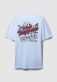 Biała bawełniana koszulka z graficznym nadrukiem z czerwonym i czarnym tekstem, kostkami do gry i kartami, z napisem "Co się dzieje w VEGAS." Luźny krój.