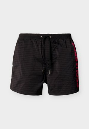Shorts de bain pour hommes noirs avec taille élastique, cordon noir, motif subtil de texte répété, et marquage rouge vif "DSQUARED2" sur le côté.