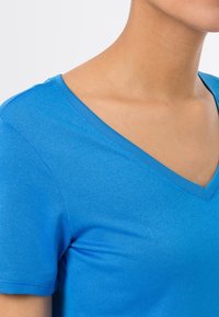 Camiseta azul de cuello en v hecha de tela de algodón suave, con mangas cortas y detalles de costura impecables en el escote.