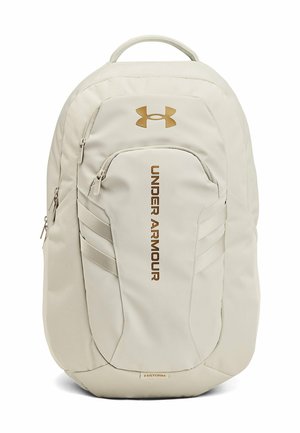 Licht beige Under Armour rugzak met meerdere ritssluitingen en het merklogo en naam in bruin op het voorpaneel.