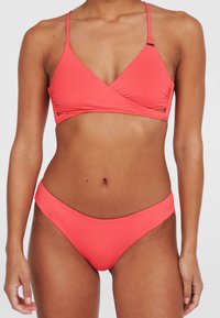 Korallā krāsā bikini komplekts, kurā ir apvērsts stila trīsstūrveida tops ar regulējamām siksnām un atbilstošs zems vidukļa apakšdaļa, kas izgatavots no gludas elastīgas auduma.