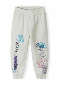 Pantalon de survêtement blanc avec taille élastique ; présente un texte et des motifs de style graffiti colorés en bleu, violet et rose.