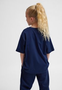 Mörkblå bomulls t-shirt med korta ärmar, avslappnad passform och rundad hals, i kombination med matchande mörkblå byxor. Slät textur, utan mönster.