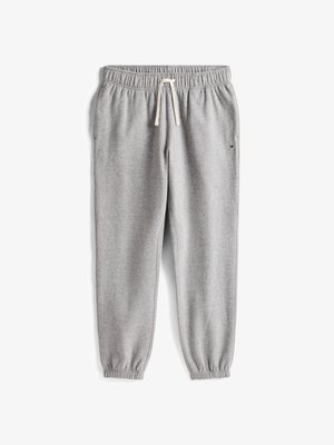 Graue Jogginghosen aus weichem Material, ausgestattet mit einem elastischen Bund mit Kordelzug und elastischen Bündchen an den Knöcheln. Kleines Logo-Detail vorhanden.