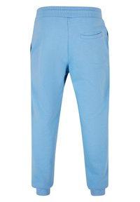 Ljust blå sweatpants i mjukt material, med elastisk midja, mudd vid anklarna och två sidofickor.
