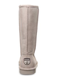 Hellgraue Wildleder-Stiefel bis zum Knie mit abgerundeter Zehenpartie, genähten Nähten und einem Markenpatch an der Ferse. Flache Gummisohle. Weiche, sichtbare Innenausstattung.