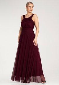 Bordowa suknia z luźnego materiału, z dopasowanym gorsetem, dekoltem w kształcie łódki i warstwową spódnicą z tiulu zapewniającą elegancki ruch.