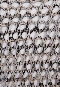 Knit fabric in cream, beige, and black with an open weave design. Features interwoven threads creating a geometric pattern. Soft texture.
