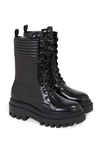 Černé bojové boty z lesklé kůže, s žebernatým panelem a šněrováním vpředu, s tlustou, robustní podrážkou.