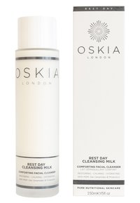 Hvid cylindrisk flaske med pumpe, mærket "Rest Day Cleansing Milk." Accompanjeret af en matchende hvid æske med sølvtekst.