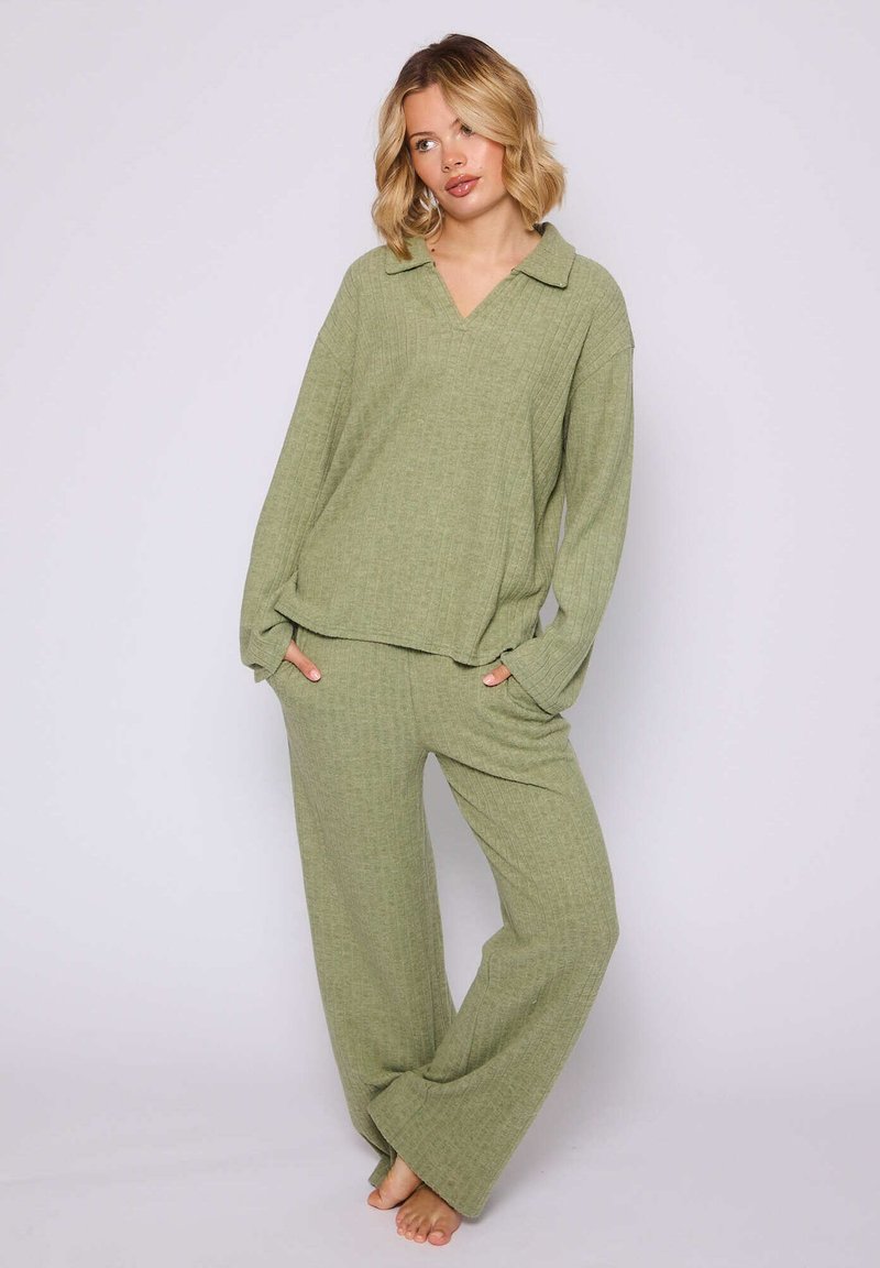 Ensemble de vêtements de détente vert, texturé, comprenant un haut à manches longues et décolleté en V, ainsi que des pantalons larges, tous deux avec des poches et une coupe décontractée.