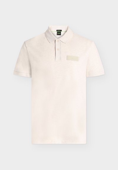Polo beige clair à manches courtes avec patte à deux boutons et petit écusson rectangulaire « BOSS » sur la poitrine gauche.