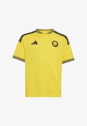 Maglia sportiva gialla a maniche corte con colletto e polsini neri decorati, strisce nere sulle spalle, logo Adidas ed emblema del club di calcio Al Nassr.