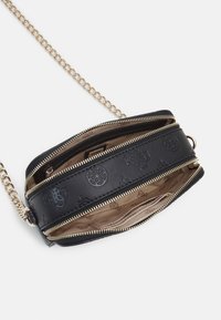 Czarna skórzana torba z złotym łańcuszkowym paskiem, wieloma kieszeniami na zamek, tłoczonymi zdobieniami oraz beżowym wnętrzem z wzorzystą podszewką.