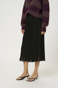 Must mustriga seelik voolava disainiga, koos mustade kontsadega sandaalidega. Komplekti kuulub lilla triibuline kootud kampsun.