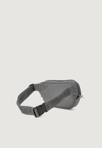 Borsa a tracolla grigia in tessuto, con chiusura a zip, tracolla regolabile con stampa "TOMMY JEANS" e forma compatta e rettangolare.