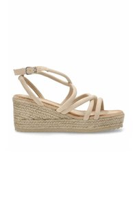 Sandalia de cuña beige con correas de ante entrelazadas, plataforma de yute trenzado y hebilla ajustable en el tobillo. Textura suave, diseño de punta abierta.