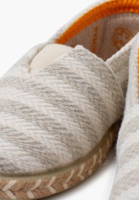 Espadriller lavet af vævet cremefarvet og lysegrå stof med en jutesål, prydet med et orange indvendigt og en v-formet foran.