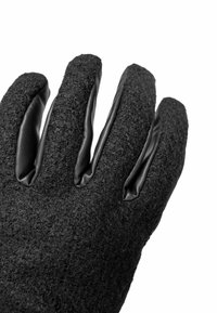 Schwarze Handschuhe mit einer strukturierten Wollaußenseite und glatten Lederakzenten an den Fingerspitzen, die einen Kontrast in den Materialien bieten.