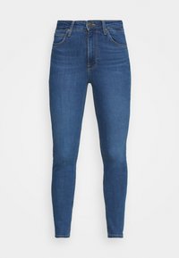Vaqueros ajustados en denim azul oscuro, con cintura alta, bolsillos frontales y costuras clásicas. Textura suave con un ligero desgaste en los muslos.