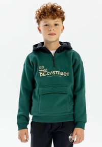Zöld kapucnis pulóver fekete kapucnival, cipzárral és elülső zsebbel. A "DE-C/STRUCT URBAN CULTURE" felirat nyomtatott rajta, valamint texturált anyaggal rendelkezik.