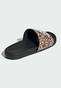 Sandały typu slide z górną częścią w leopardzi wzór w odcieniach beżu i brązu, z czarną gumową podeszwą i wytłoczonym logo na wkładce.