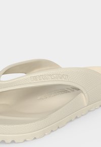 Μπεζ σαγιονάρα Birkenstock από αφρώδες υλικό με υφή στη σόλα και λογότυπο ανάγλυφο στο λουράκι και στην πάτο.