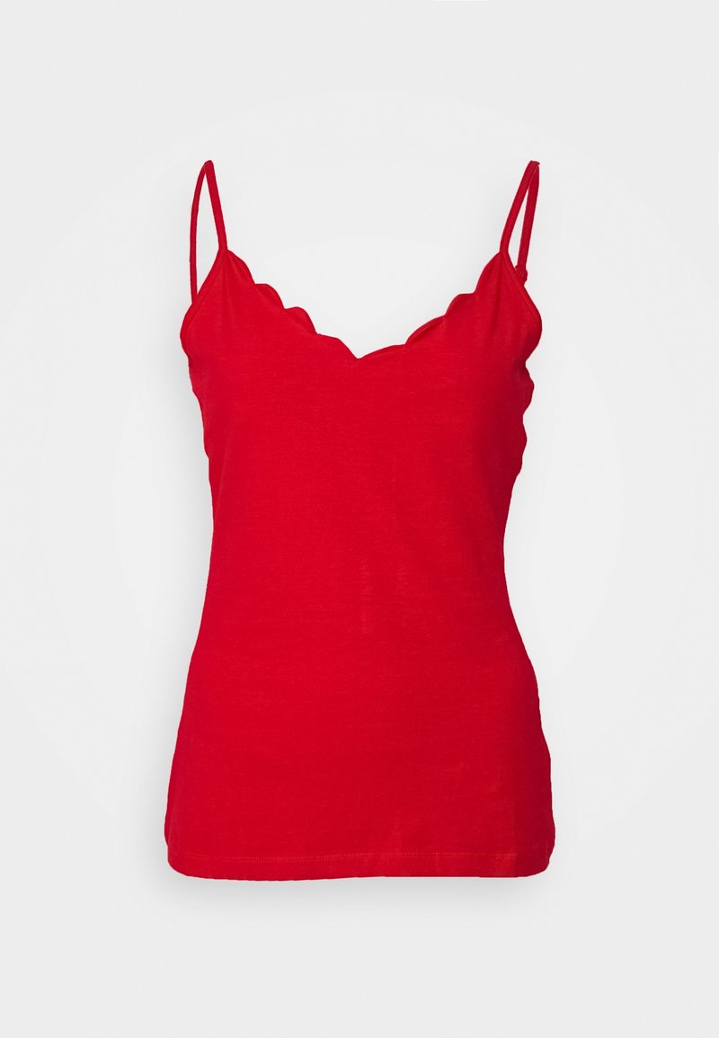 Haut débardeur rouge avec encolure festonnée et fines bretelles sur fond uni.