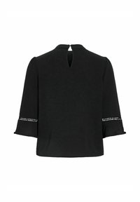 Blouse noire à manches longues avec fermeture en trou de serrure au col et bordure décorative découpée en losange au-dessus des poignets évasés, vue de dos.