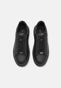 Svarta lädersneakers med runda tå, platta snören och en liten silverlogga på sidan. Inuti finns en vadderad foder för extra komfort.