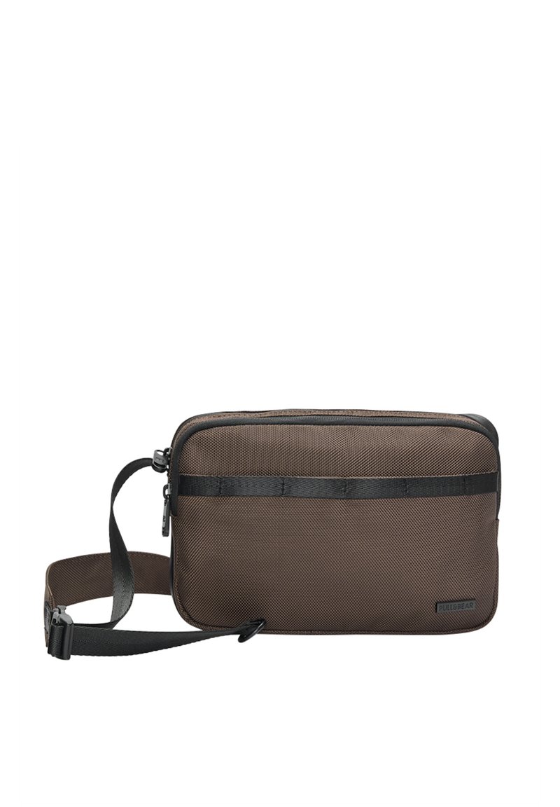 Braune, rechteckige Tasche aus strukturiertem Material mit schwarzen Akzenten, einem Schultergurt und einem Reißverschluss. Pull&Bear-Logo sichtbar.