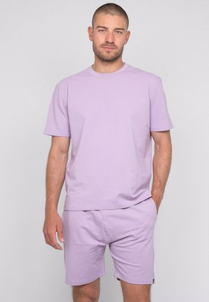 T-shirt en coton lilas à manches courtes associé à un short lilas assorti. Texture lisse et coupe décontractée, sans motifs ni ornements visibles.