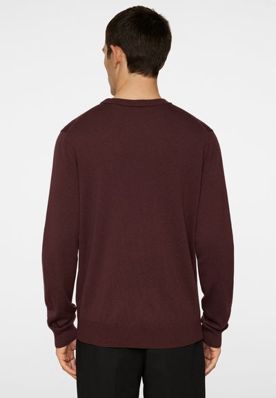 Bordeaux gebreide trui met lange mouwen en een geribde onderkant. Heeft een klassieke ronde halslijn en een soepele textuur. Eenvoudig ontwerp, zonder zichtbare patronen.