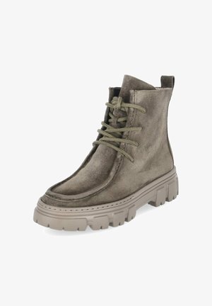 Bota de ante verde hasta el tobillo con cordones, suela gruesa de goma beige y lengüeta en la parte trasera.