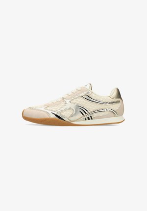 Light beige athletic shoe with gold accents, mesh panels, and black stripes; features a round toe and textured gum rubber outsole.